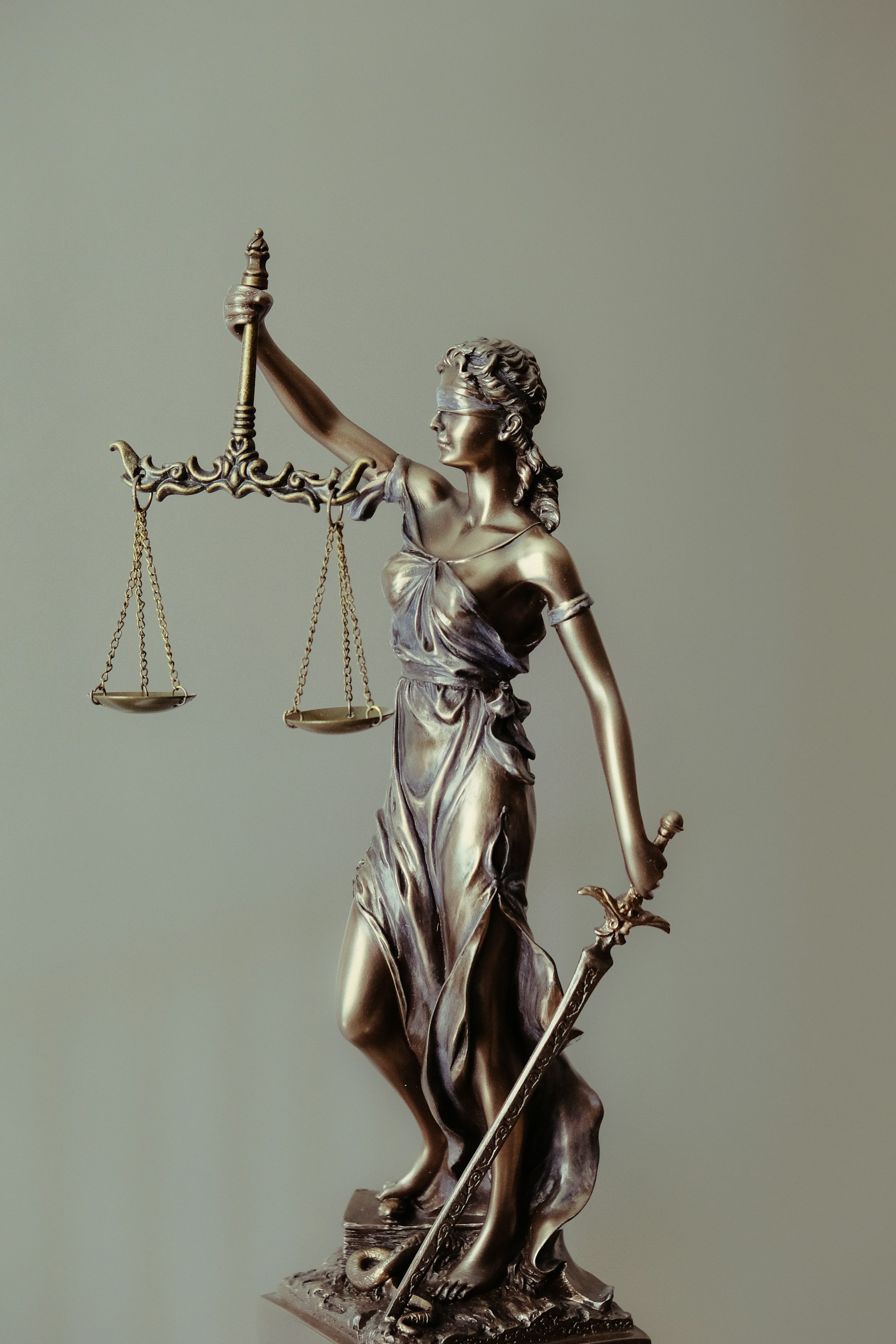 Estatua de la justicia con balanza y espada en tono dorado